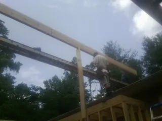 Carpenter setting a ridge beam over a new addition frame — Ice Dam Removal by Roofing Brothers in Post Falls