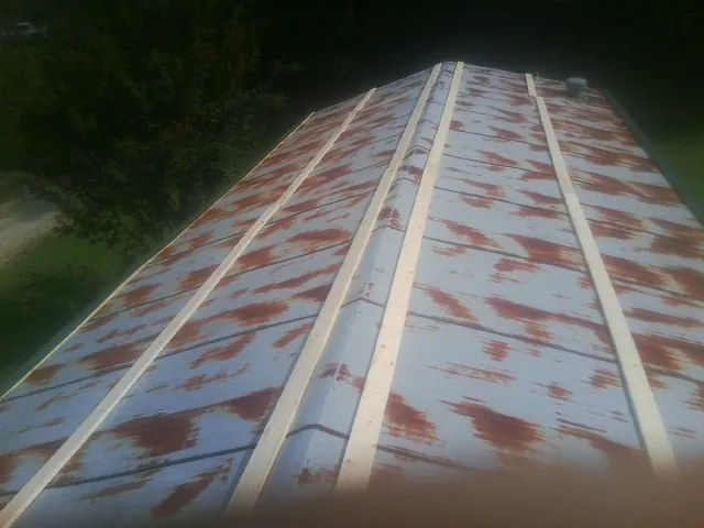 Rusted metal roof panels with new wood purlins before replacement — Storm Damage Roof Repair in Post Falls by Roofing Brothers