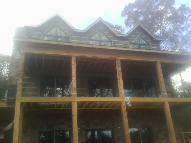 Dormers and porch framing on a large log home under construction — Roof Coating work by our crew in Post Falls
