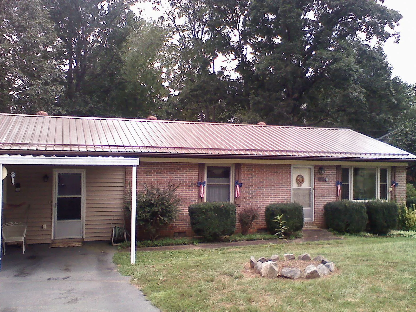 Bronze metal roof and carport on a brick ranch home — Roof Repair work by our crew in Post Falls